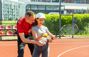 Tennis with girl. Father wearing t-shirt playing tennis with his active lovely girl.