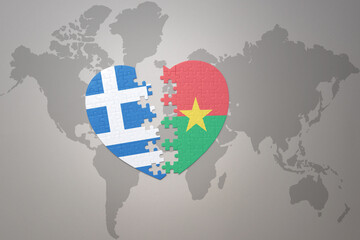 puzzle heart with the national flag of burkina faso and greece on a world map background.Concept.