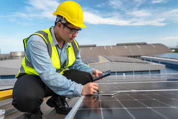 Asian engineer inspecting installation of solar panels installed on factory roof, technician,...