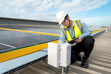 Engineer checking installation of solar panels installed on factory roof, checking installation of...