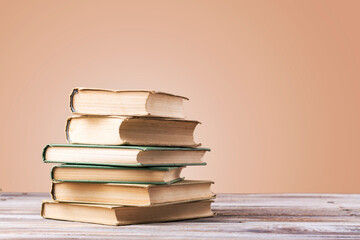 Book with opened pages in shape of heart and stacked books on reading desk in library. National...