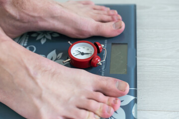 Low Section Of Overweight Obese Person Measuring Body Weight On Weighing Scale