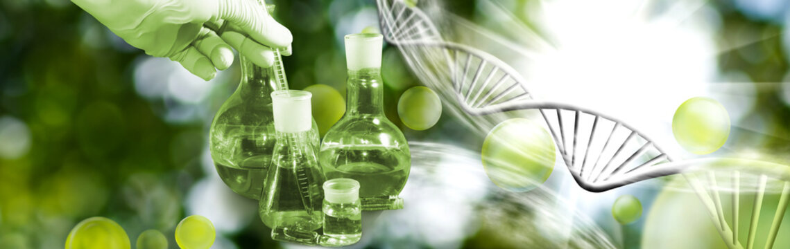 Image of a laboratory assistant's hand with a measuring tube immersed in a flask and other flasks next to it against the background of stylized DNA chains.