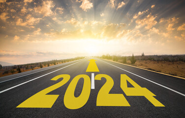 The word 2024 written on the highway. 2024 target indicated by arrow on empty asphalt road. Coming into the new year