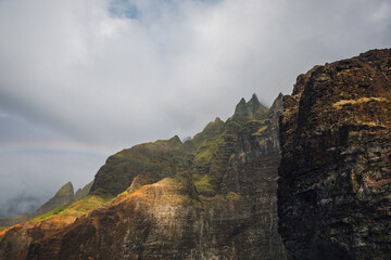Fog over the mountains of the NaPali Coastline on the island of Kauai, Hawaii on a cloudy day from a sunsets boat cruise