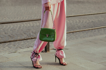 Street fashion details: woman wearing trendy pink suit trousers, high heeled strap sandals,...