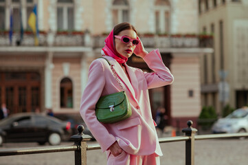Fashionable elegant confident woman wearing trendy pink sunglasses, silk headscarf, suit blazer,...