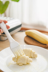 Butter the croissant dough. to prepare for making croffles.