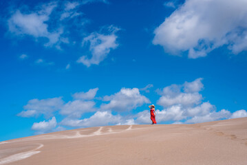 Woman posing outdoors on a sand dune on a sunny day. Summer concept.