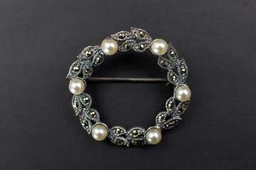Vintage silver brooch on black background, old accent retro jewelry for women, promotional photo for an online jewellery store