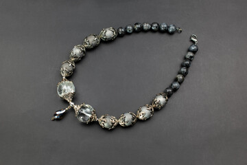 Gray gemstone crystal beads necklace on black, unique handmade jewelry background