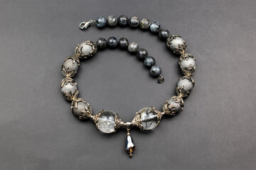 Gray gemstone crystal beads necklace on black, unique handmade jewelry background
