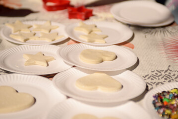 Cut out figures from dough in disposable cardboard plates. The process of making cookies or shortbread.