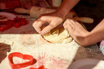 The girls knead the dough and cut out figures of various shapes. The process of making cookies or shortbread.