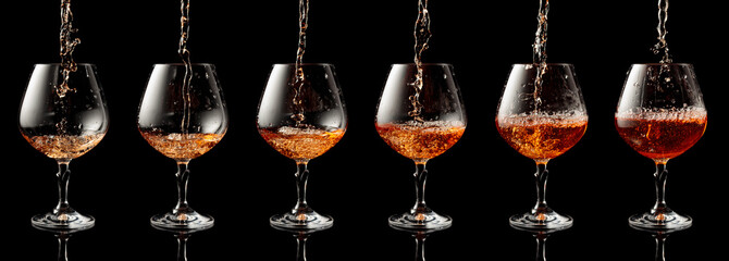 Pouring brandy into a glass on a black background.