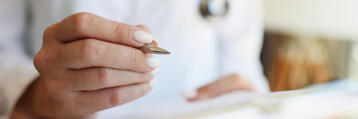 Hands of cardiologist or pediatrician doctor take notes with pen with medical letter