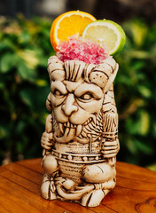 Cocktail tropical de ron y frutas servido en un vaso Tiki