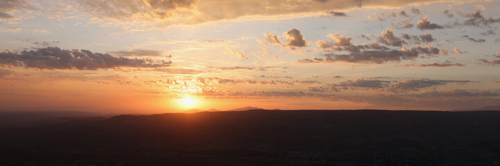 Fototapeta na wymiar Last rays of sun against backdrop of plains and mountains