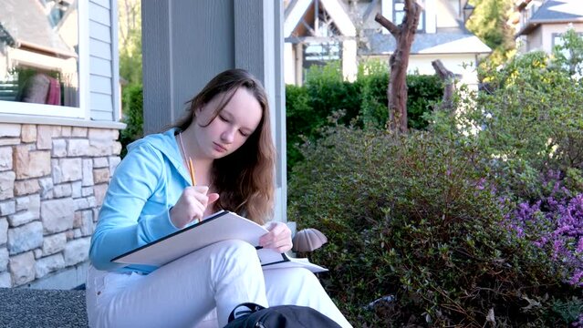 draw in an album with a simple pencil girl sits draws in nature an eraser erases what she wrote looks into the distance and begins to erase the past again to start the future of a new clean slate