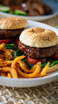 Vegan hamburger with curly fries on the side