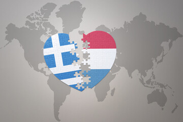 puzzle heart with the national flag of luxembourg and greece on a world map background.Concept.