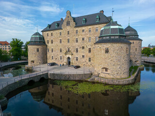 Orebro, Sweden, June 16th 2023. Orebro castle on Svartan river early in the morning.