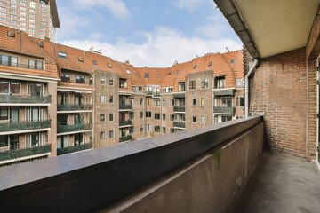 an apartment building with brick walls and balks on the roof, looking out onto the street from the balcony