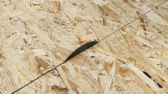 OSB Oriented strand board plate being cut by circular saw disk