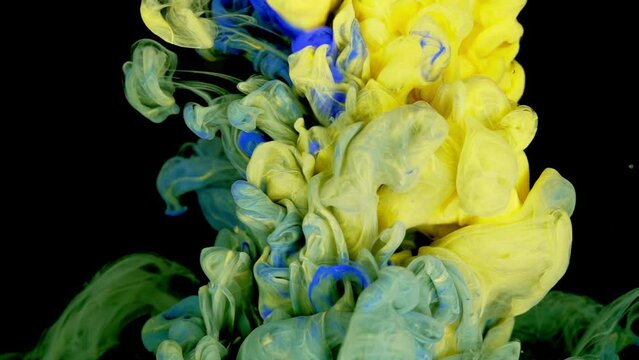 Vibrant Chromatic Fusion: Blue, Green, and Yellow Paints Mixing in Water