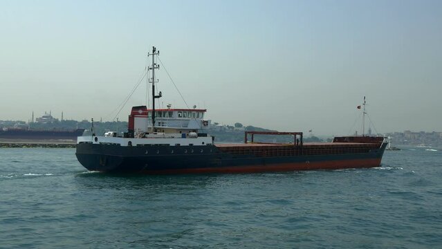 Dry cargo ship sailing into calm sea. Cargo ships are intended basically for carrying of bulk cargoes such as coal and timber. 4K Tracking shot of a general cargo ship
