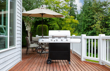 Home outdoor wood deck with large BBQ grill cooker during summer time