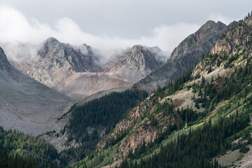 A moody stormy landscape with high mountain peaks, near the ghost town of Ashcroft. Recreational activities can be found in the rugged mountains of Central Colorado.	