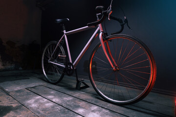 Fototapeta na wymiar gray street sports bike in a dark room illuminated by red light