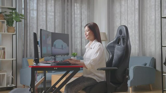 Side View Of Asian Female Automotive Designer Working On 3D Model Of Ev Car On The Desktop Computers In The Studio
