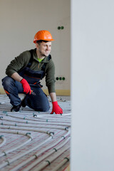 Worker is installing underfloor heating system. Warm floor heating system