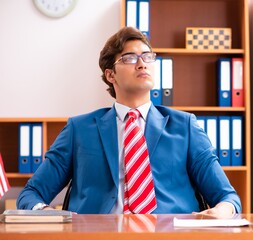 Young handsome politician sitting in office