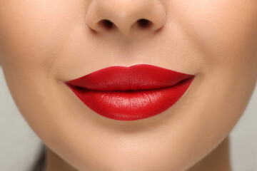 Woman with red lipstick on light background, closeup