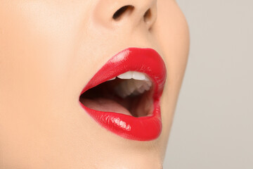 Woman with red lipstick on light background, closeup