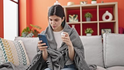 Young beautiful hispanic woman looking for pills information being sick at home