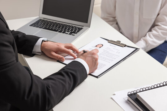 Human resources manager reading applicant's resume in office, closeup