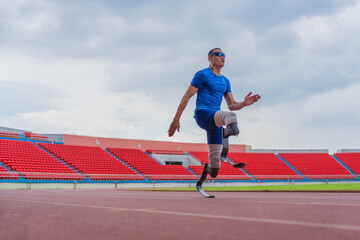 Asian male athlete with prosthetics runs at full speed, demonstrating a powerful practice on stadium track