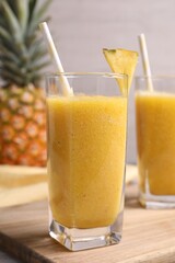 Tasty pineapple smoothie and fresh fruit on table