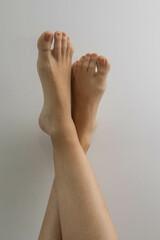 studio photo of bare feet with pedicure and short nails, care of human body parts, hygiene and...