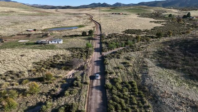 Drone shot of car driving on dirt road in Willcox, Arizona, following aerial shot