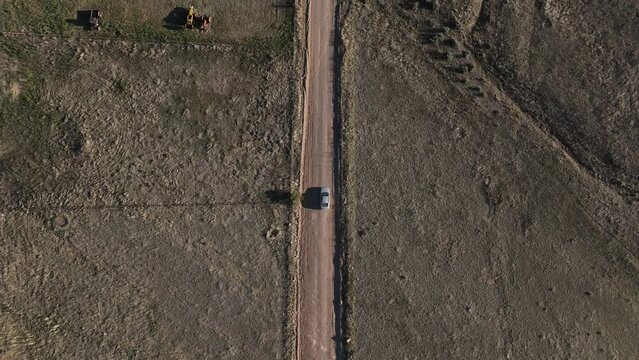 Drone shot of car driving on dirt road in Willcox, Arizona, epic downward angle aerial shot
