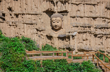 Beautiful Buddha face on sandstone cliff