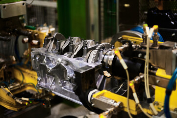 Fototapeta na wymiar Illuminated car engine on test stand in production plant shop