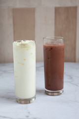 Two glasses of milkshake with assorted flavors. Chocolate and Vanilla milkshake.