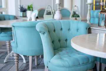 A blue armchair at an empty table in a Provence cafe.