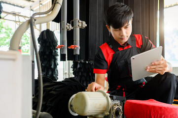 Asian maintenance people check motor control in car washing room automatic with manual control in a...